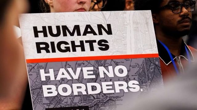 Protester holding a Human Rights Have No Borders sign